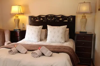 a bedroom with a bed with two towels on it at Del Roza Guest House in Middelburg