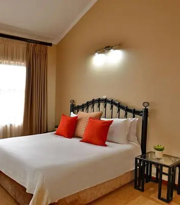 a bedroom with a large bed with red pillows at Monateng Safari Lodge in Wallmannstal
