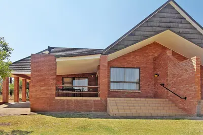 a red brick house with a porch at Monateng Safari Lodge in Wallmannstal