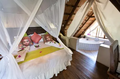 a bedroom with a bed with two dolls on it at Blyde River Canyon Lodge in Hoedspruit