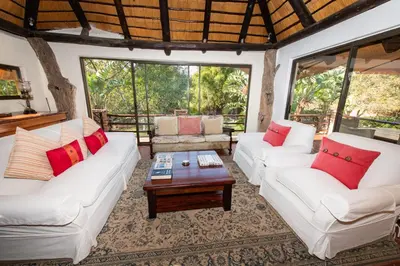 a living room with two white couches and a table at Blyde River Canyon Lodge in Hoedspruit