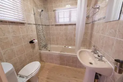 a bathroom with a toilet and a sink and a tub at Blyde River Canyon Lodge in Hoedspruit