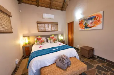 a bedroom with a large bed in a room at Blyde River Wilderness Lodge in Hoedspruit