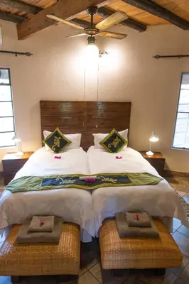 a bedroom with a large bed with white sheets and pillows at Blyde River Wilderness Lodge in Hoedspruit