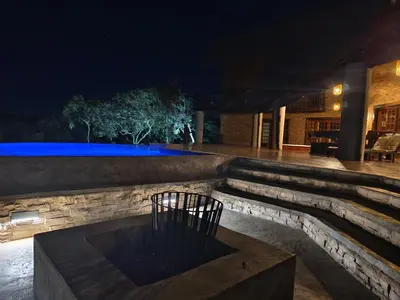 a patio at night with a bench in the middle at Tholo Private Game Lodge in Bela-Bela