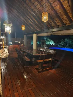 a wooden deck with a ping pong table and chairs at Tholo Private Game Lodge in Bela-Bela