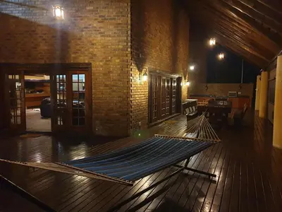 a hammock sitting on a wooden floor in a room at Tholo Private Game Lodge in Bela-Bela