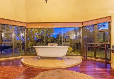 a bath tub in a room with a large window at Tholo Private Game Lodge in Bela-Bela
