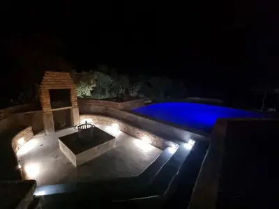 a swimming pool lit up at night with lights at Tholo Private Game Lodge in Bela-Bela