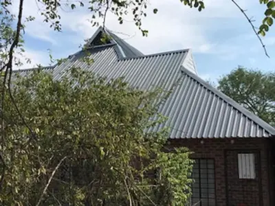 a building with a metal roof on top of it at Kruger Wild Dog Inn in Marloth Park