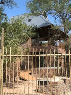 a wooden fence in front of a building at Kruger Wild Dog Inn in Marloth Park