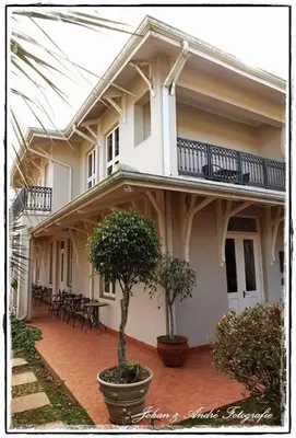 a white house with a patio with tables and chairs at Silver Mist Guest House, Country Inn and Herberg in Kaapsehoop