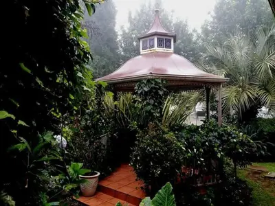 a gazebo with a tower in a garden at Silver Mist Guest House, Country Inn and Herberg in Kaapsehoop