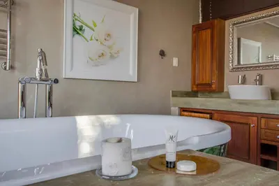 a bathroom with a white tub and a sink at Migdash Guesthouse in Hartbeespoort