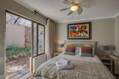 a bedroom with a large bed and a window at Migdash Guesthouse in Hartbeespoort