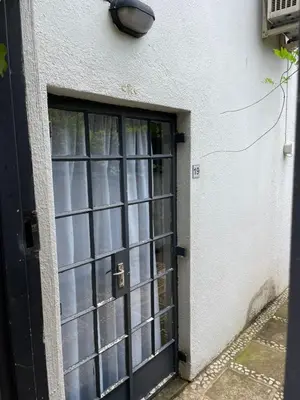 a door with a window in a white building at The Wild Peach - Menlyn in Pretoria