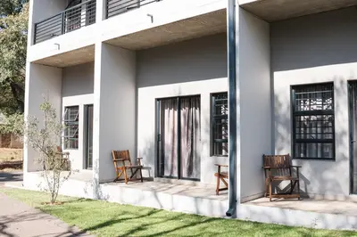 two chairs sitting on the porch of a house at The Wild Peach - Menlyn in Pretoria