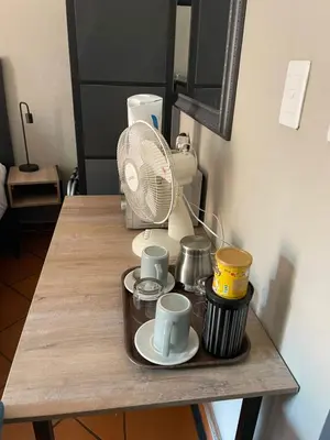 a table with coffee cups and a fan on it at The Wild Peach - Menlyn in Pretoria