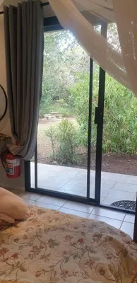 a bedroom with a window with a view of a yard at Kruger Allo B&B in Komatipoort