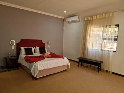 a bedroom with a large bed and a window at Guesthouse Serenity in Hartbeespoort