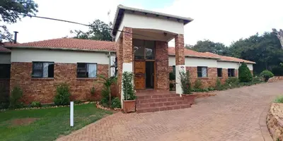 a brick house with a driveway in front of it at Guesthouse Serenity in Hartbeespoort