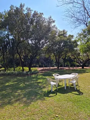a white table and two chairs in a park at Guesthouse Serenity in Hartbeespoort
