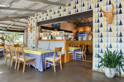 a dining room with a table and chairs at Perry's Bridge Hollow Boutique Hotel in Hazyview