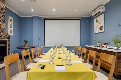 a conference room with a long table and a white screen at Perry's Bridge Hollow Boutique Hotel in Hazyview