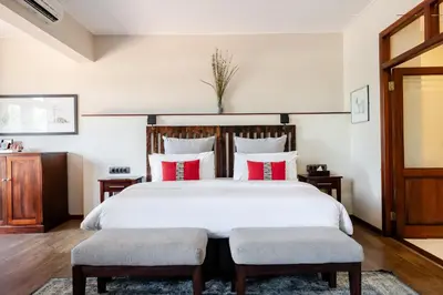 a bedroom with a large bed with red and white pillows at Casterbridge Hollow Boutique Hotel in White River