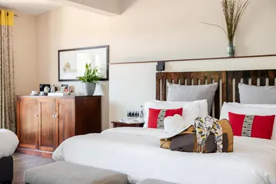 two beds in a hotel room with hats on them at Casterbridge Hollow Boutique Hotel in White River