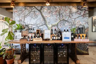a bar with bottles of wine and a tree mural at Casterbridge Hollow Boutique Hotel in White River