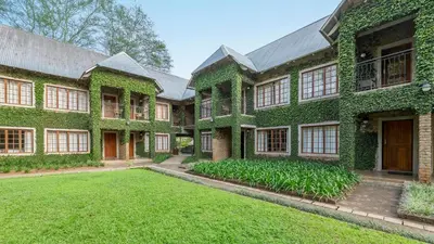 a building covered in green ivy with a yard at Hippo Hollow Country Estate in Hazyview