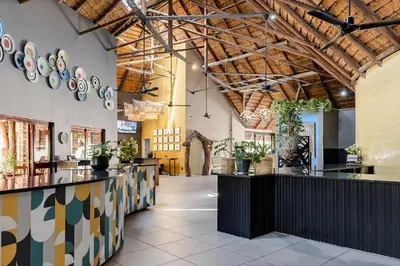 a restaurant with a bar with plants on the walls at Hippo Hollow Country Estate in Hazyview