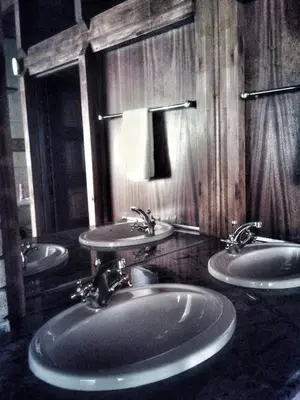 a bathroom with three sinks and a mirror at Vido Lodge and Conference Centre in Polokwane
