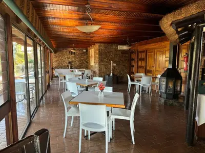 a restaurant with tables and chairs and a fireplace at Vido Lodge and Conference Centre in Polokwane
