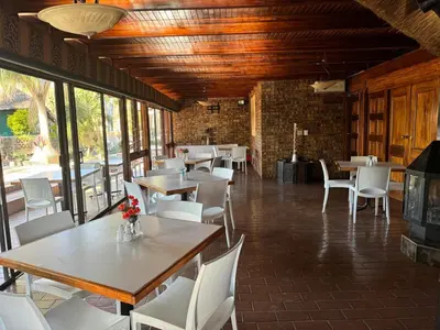 a dining room with tables and white chairs at Vido Lodge and Conference Centre in Polokwane