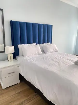 a large bed with a blue headboard in a bedroom at Airport Imperial Guest House in Kempton Park