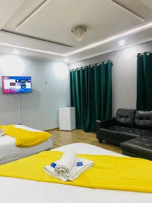 a living room with two beds and a couch at Airport Imperial Guest House in Kempton Park