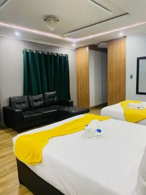 a hotel room with two beds and a couch at Airport Imperial Guest House in Kempton Park