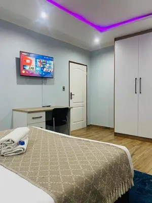 a bedroom with a bed and a tv on the ceiling at Airport Imperial Guest House in Kempton Park