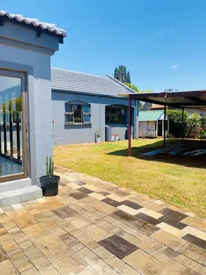 a house with a patio and a yard at Airport Imperial Guest House in Kempton Park