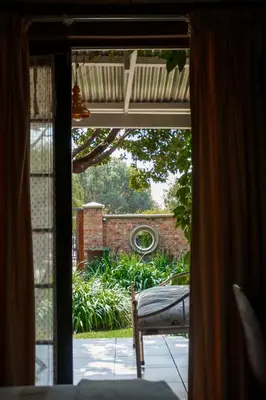 an open door to a patio with a view of a garden at Town and Country Mpumalanga in Middelburg