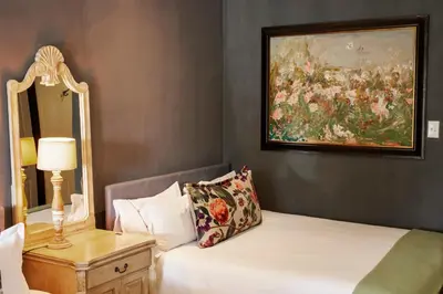a bedroom with a bed with a painting on the wall at Town and Country Mpumalanga in Middelburg