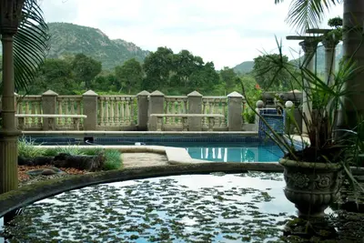 a swimming pool with a water feature in a yard at Belvedere-on-River in Malelane