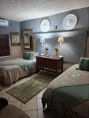 a bedroom with two beds and a desk and two lamps at Belvedere-on-River in Malelane