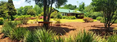 a garden with a house in the background at Stanford Lake lodge in Haenertsburg