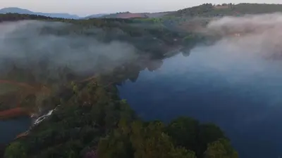 an aerial view of a lake in the middle of a forest at Stanford Lake lodge in Haenertsburg