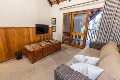 a living room with a couch and a television at Legend Safaris 257B - in Kruger Park Lodge in Hazyview