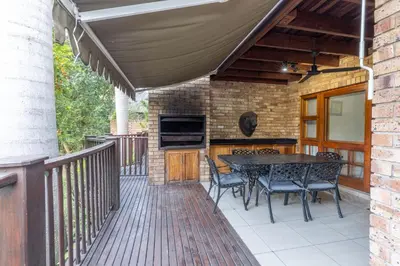 a patio with a table and chairs on a deck at Legend Safaris 257B - in Kruger Park Lodge in Hazyview
