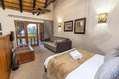 a bedroom with a bed and a couch in a room at Legend Safaris 257B - in Kruger Park Lodge in Hazyview